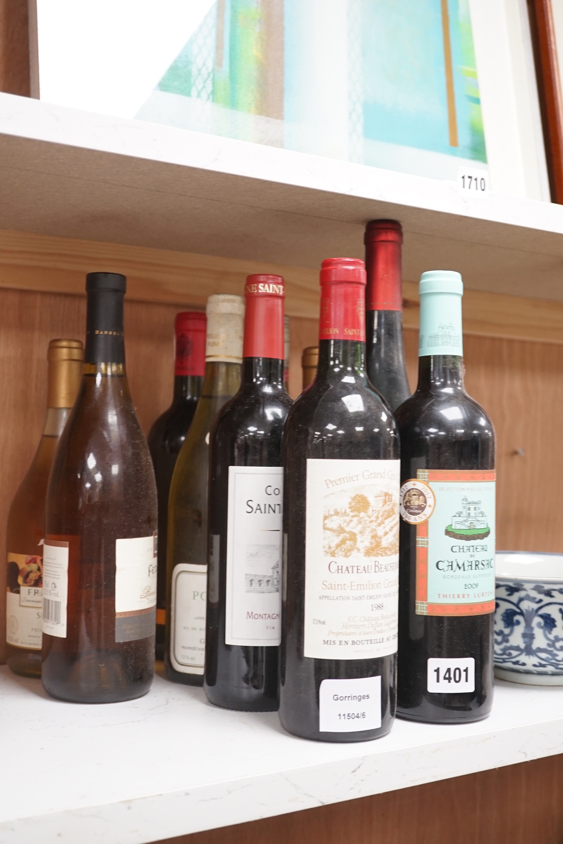 Thirteen bottles of mixed red and white wines, including a bottle of Chateau Beausejour Saint-Emelion premier grande cru 1988 and Saint- Emilion grande cru 2015 etc